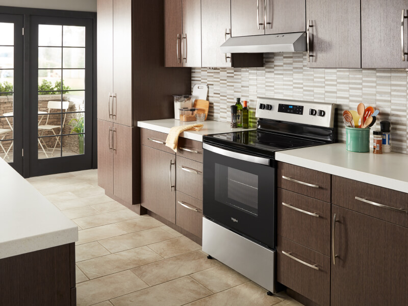 Whirlpool® electric range in a modern kitchen with a range hood above