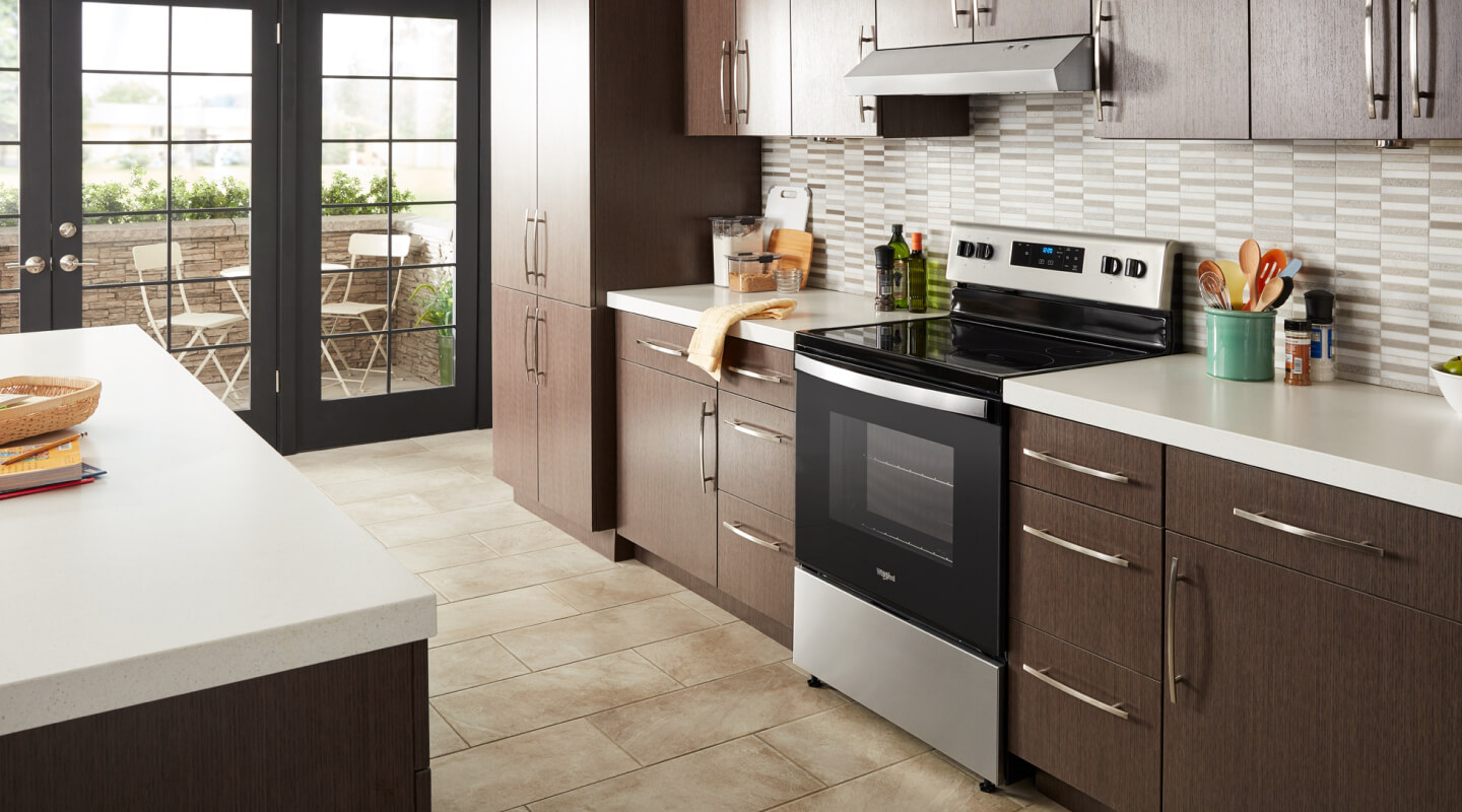 Whirlpool® electric range in a modern kitchen with a range hood above