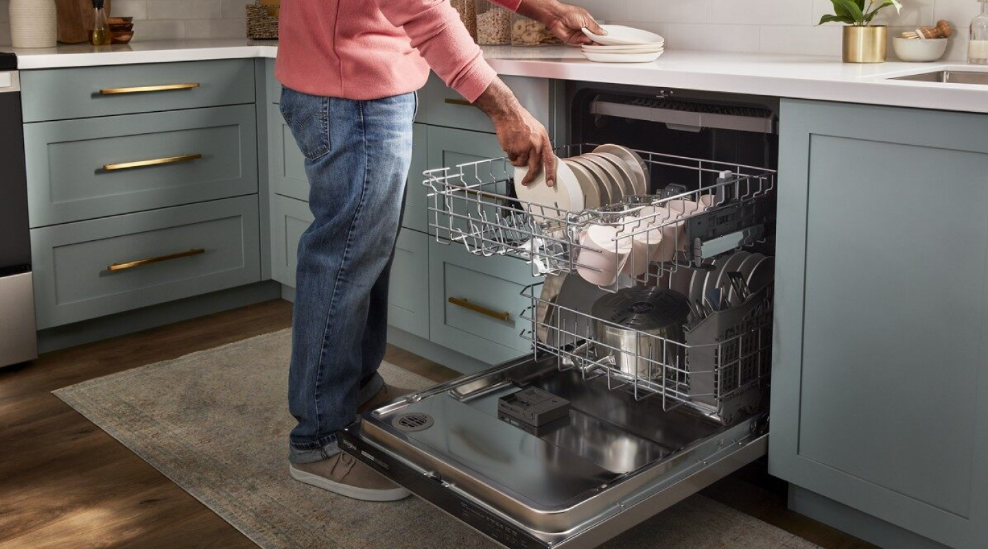A person loading dishes into a dishwasher