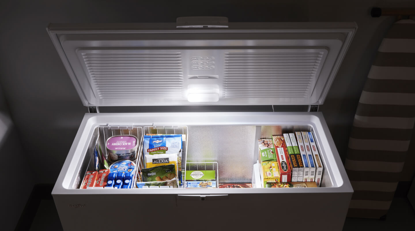 An open chest freezer stocked with frozen food