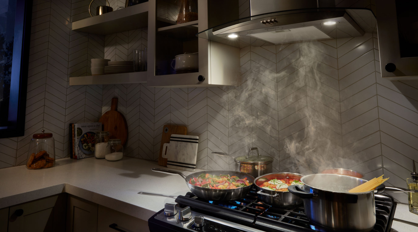 A range hood drawing up smoke from various dishes