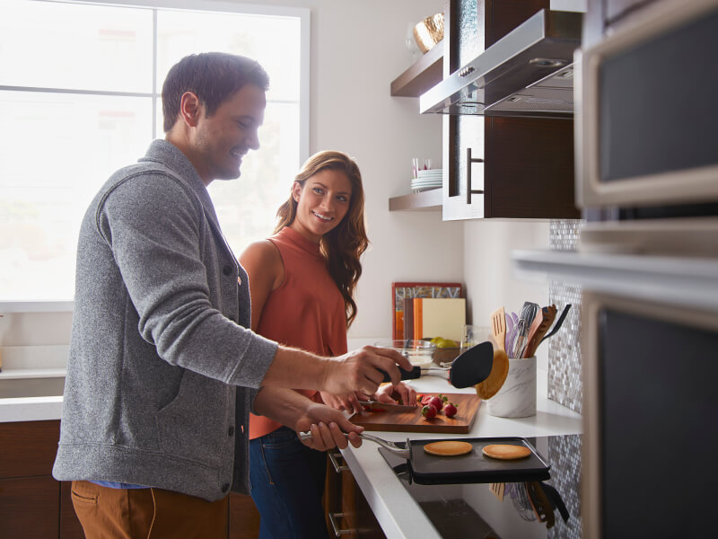 Man and woman preparing food in a kitchen