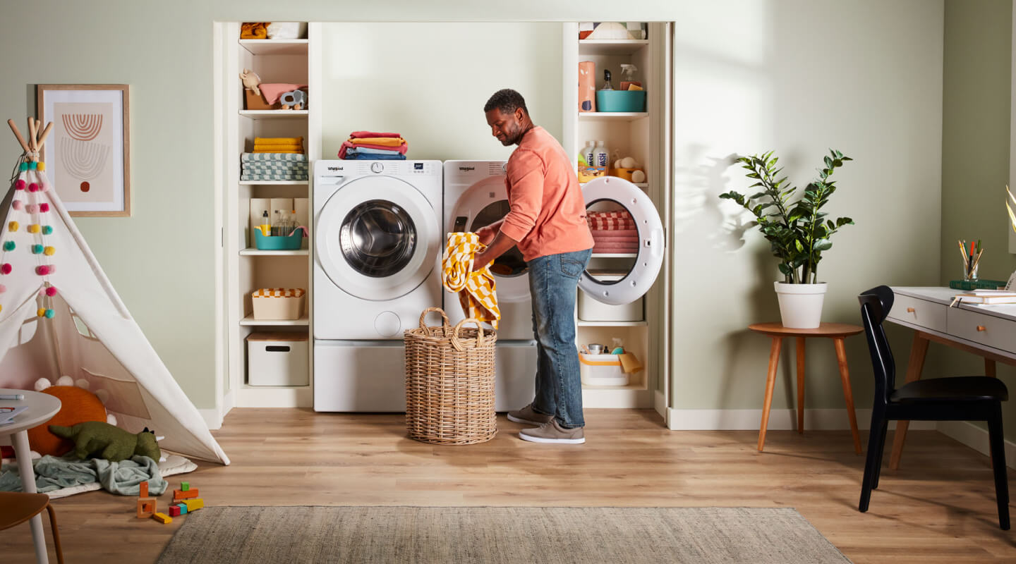 A person pulling clothes out of a dryer