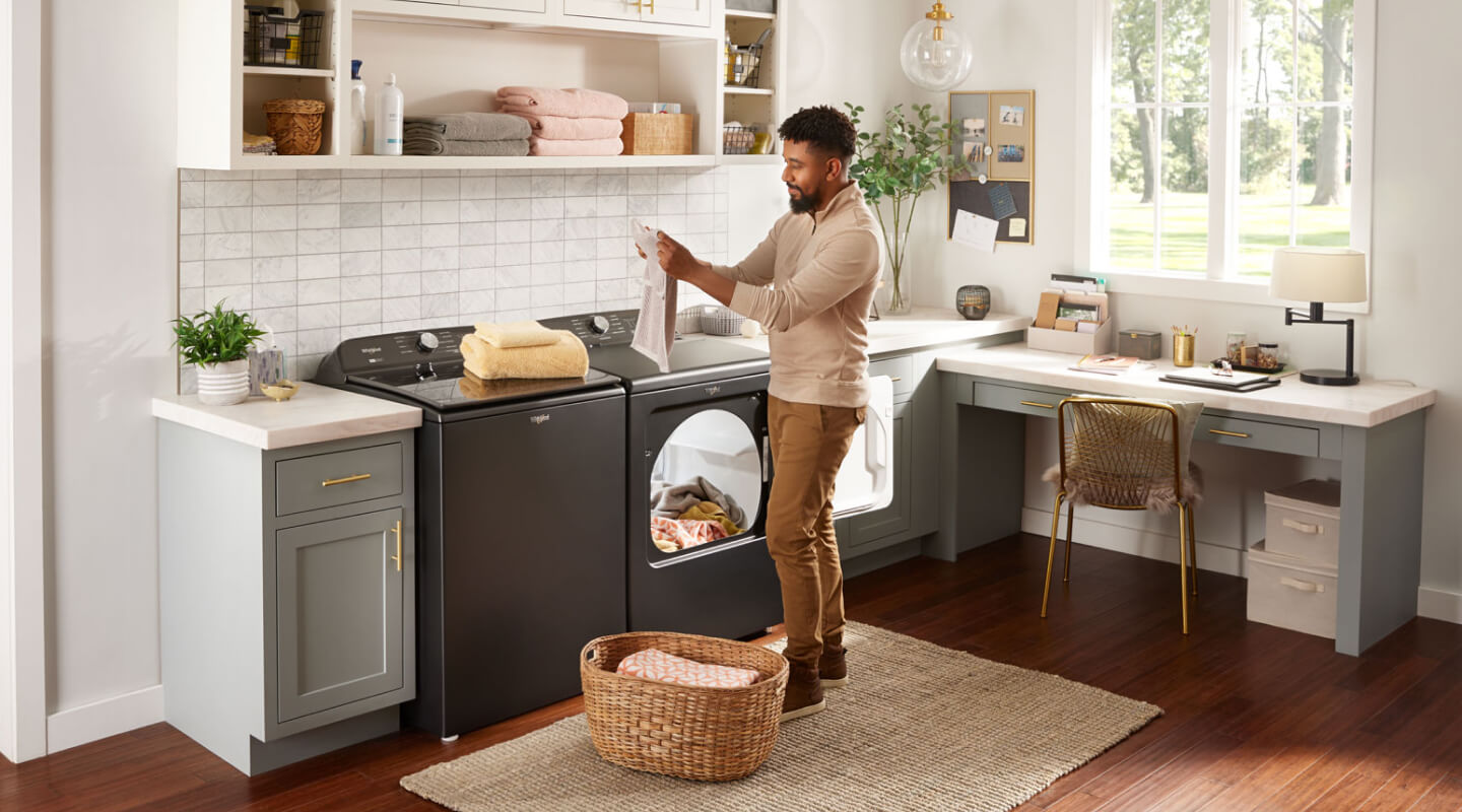 A person pulling clothes out of a dryer