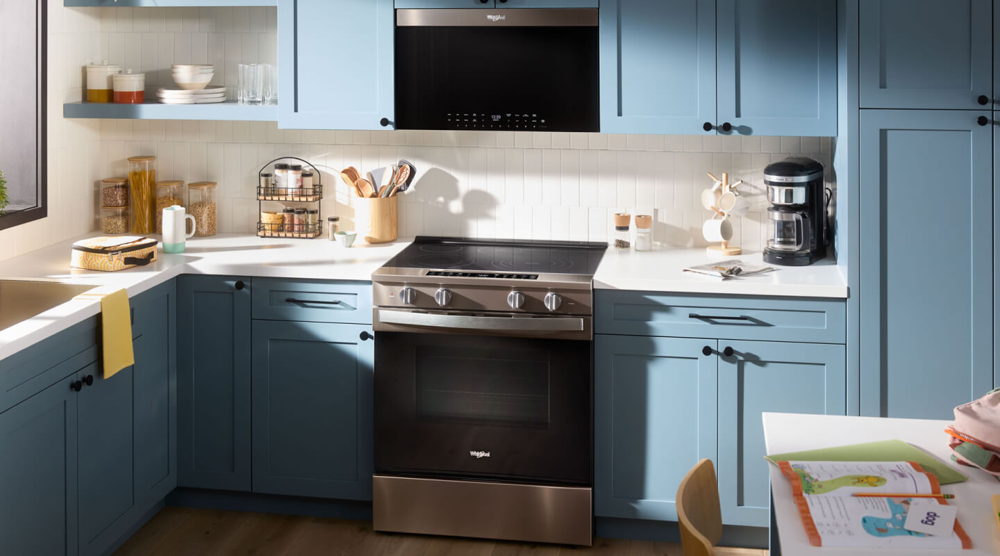 A kitchen with a Whirlpool® Slide-In Electric Range and above-the-range microwave