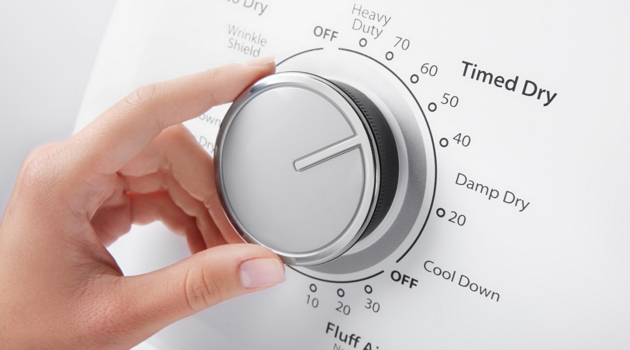 Person selecting a dryer cycle on a Whirlpool® Dryer