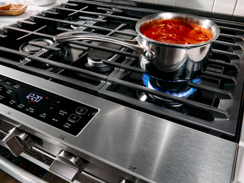Pasta sauce cooking on top of a gas stove