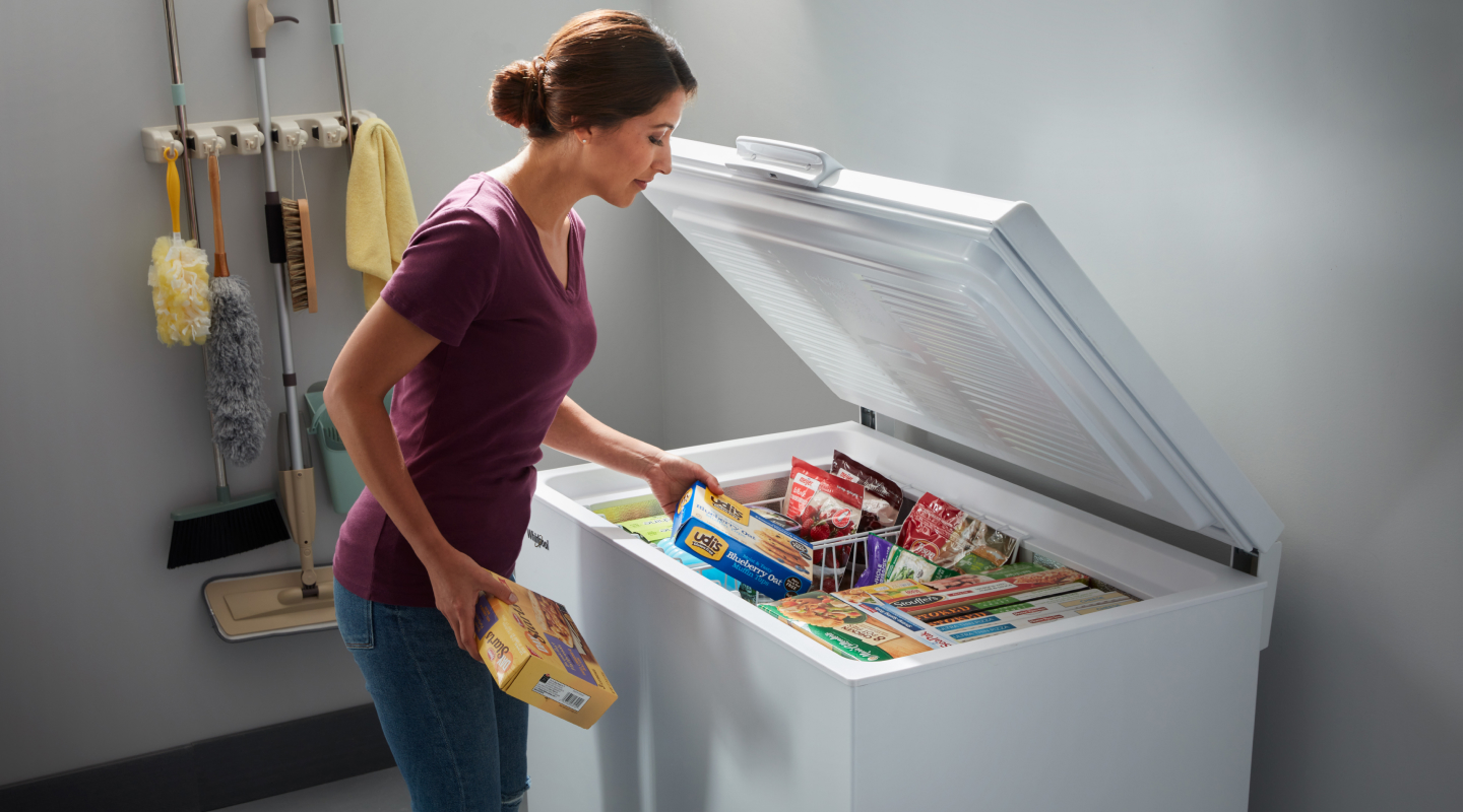 Person loading food into a chest freezer