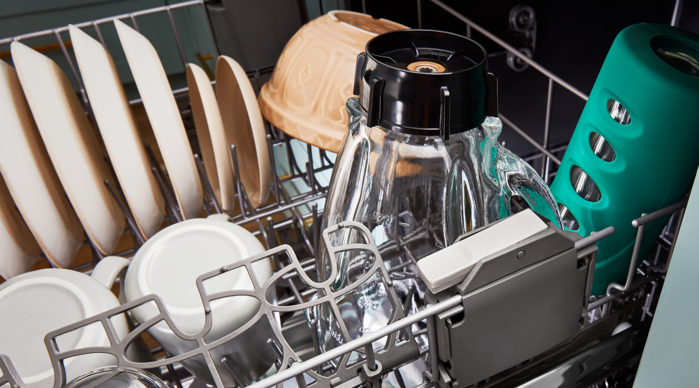 The bottom rack of a Whirlpool® dishwasher filled with dishes.