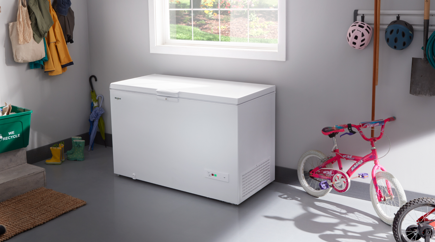 A Whirlpool® deep freezer in a garage.