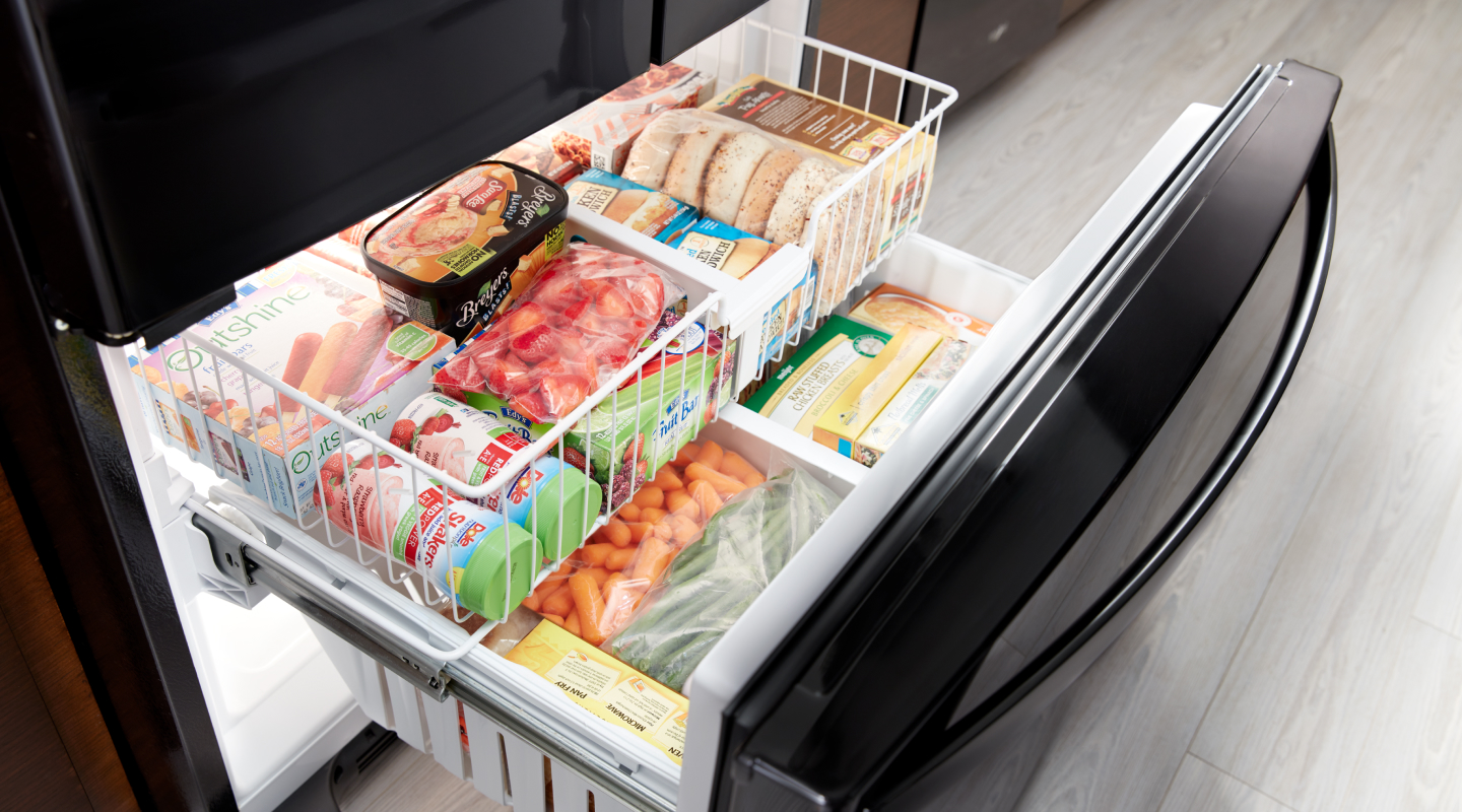 Ice cream, bread, vegetables and frozen meals organized in a freezer.