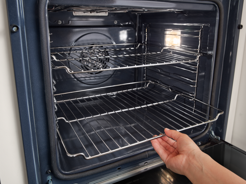 Person removing an oven rack from a Whirlpool® oven