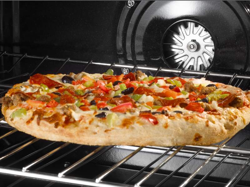 A flatbread pizza cooking in an oven