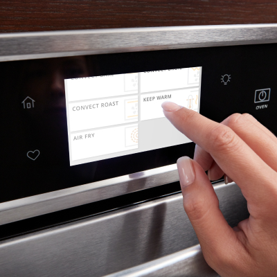 A finger pressing a digital control