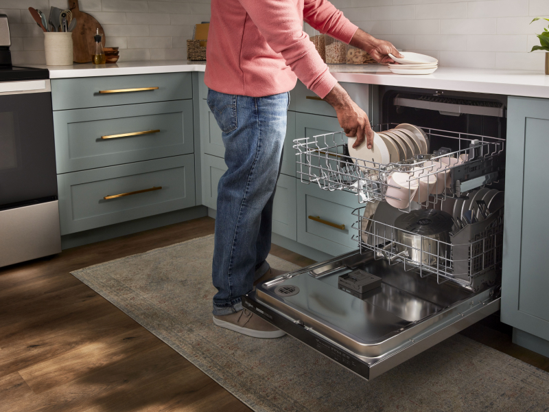 Person loading dishes into a dishwasher