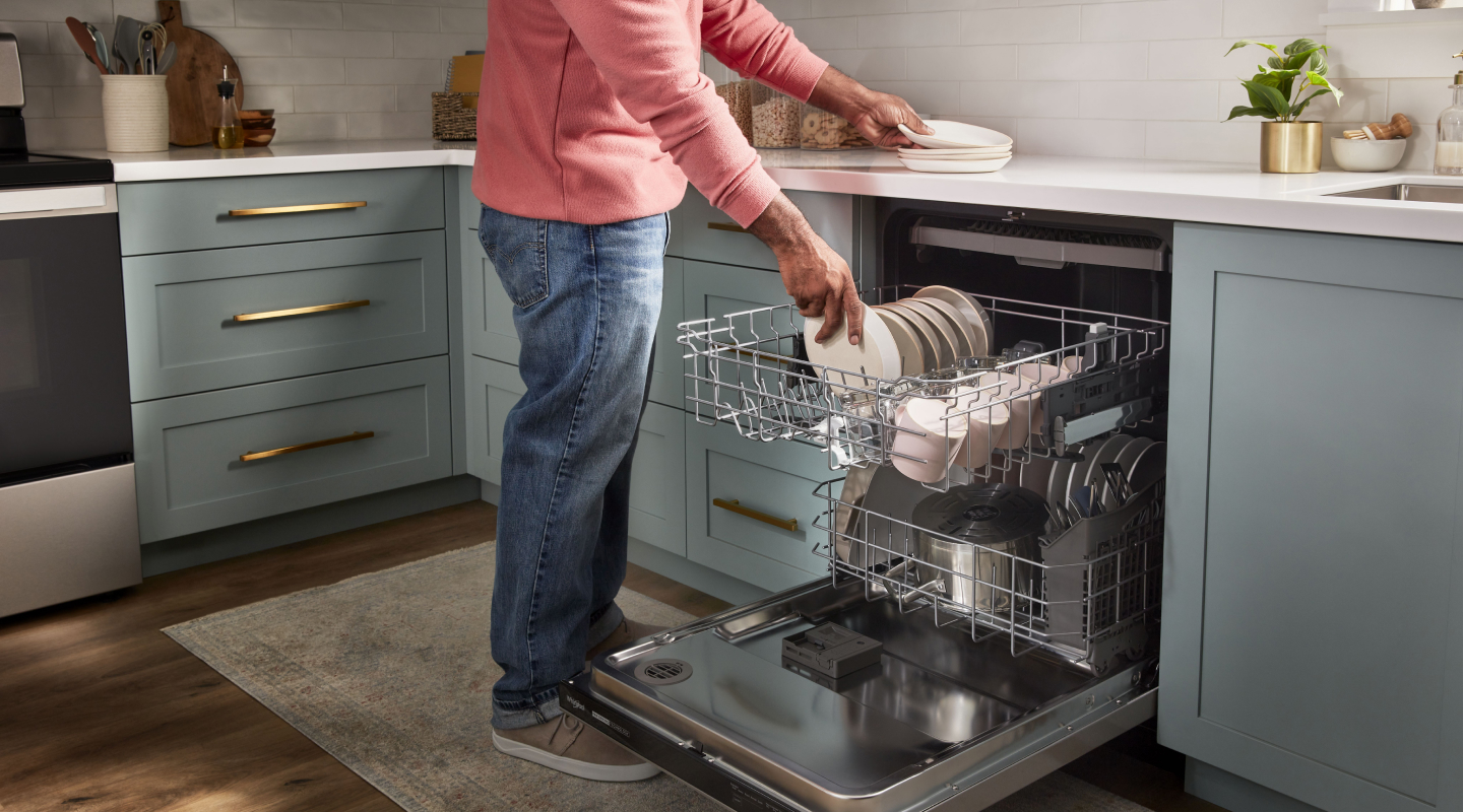 Person loading dishes into a dishwasher