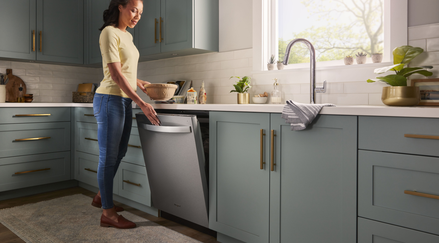 Person opening a stainless steel dishwasher