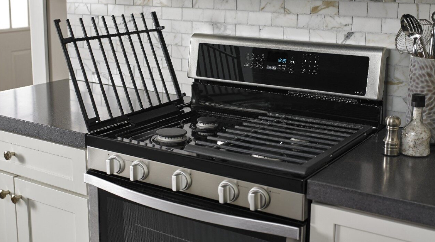 A slide-in range with the left grates lifted up.
