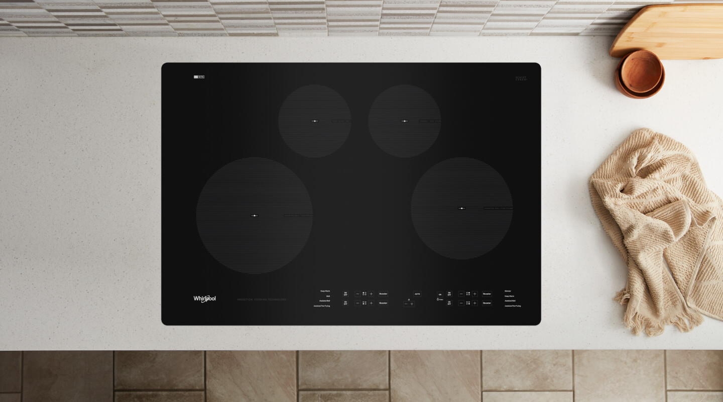 Birds-eye view of an induction stovetop built into a white countertop