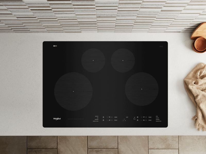 Birds-eye view of an induction stovetop built into a white countertop