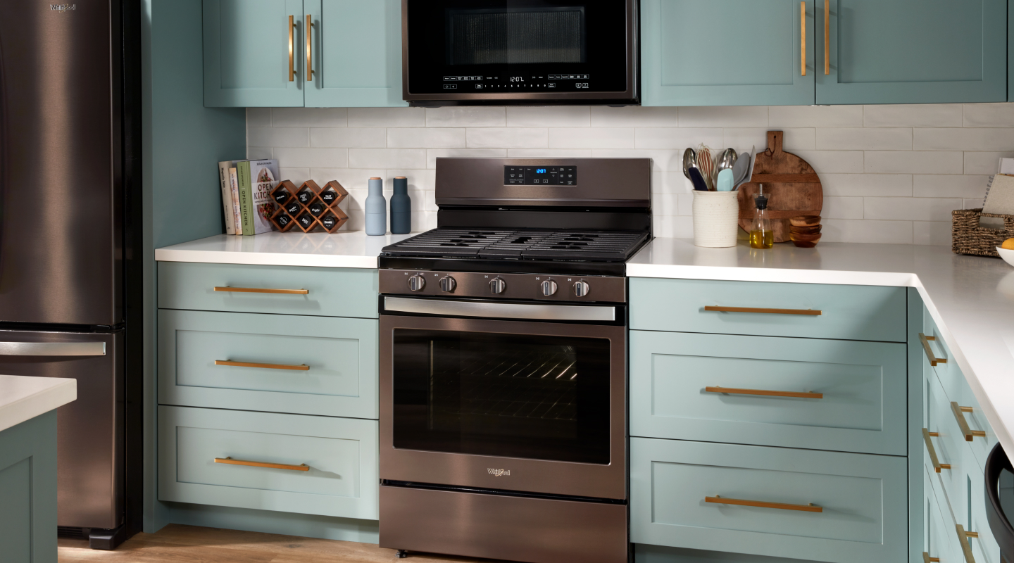 Stainless steel range surrounded by blue cabinets