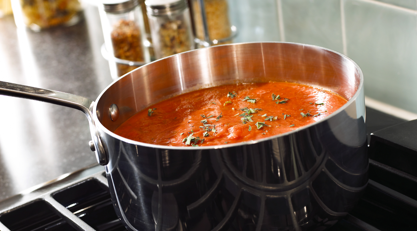 Stainless steel pan simmering on a Whirlpool® Gas Range