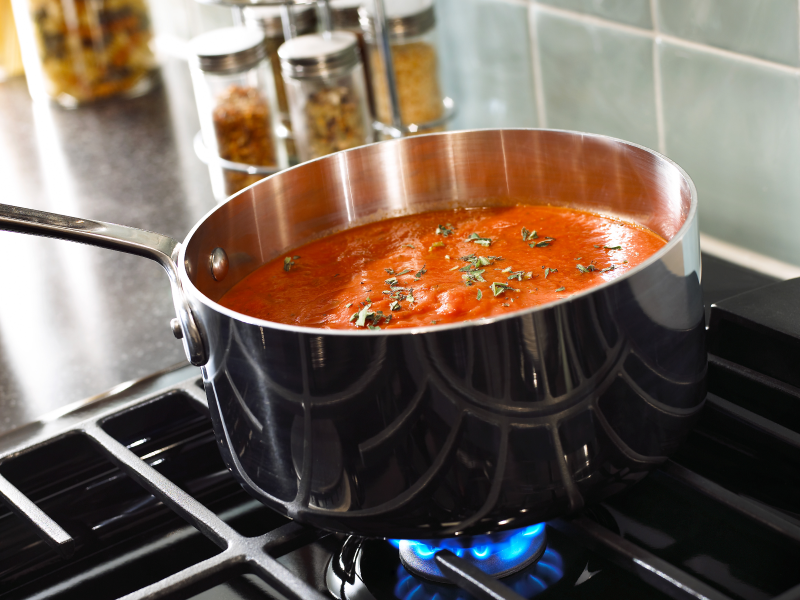 Stainless steel pan simmering on a Whirlpool® Gas Range