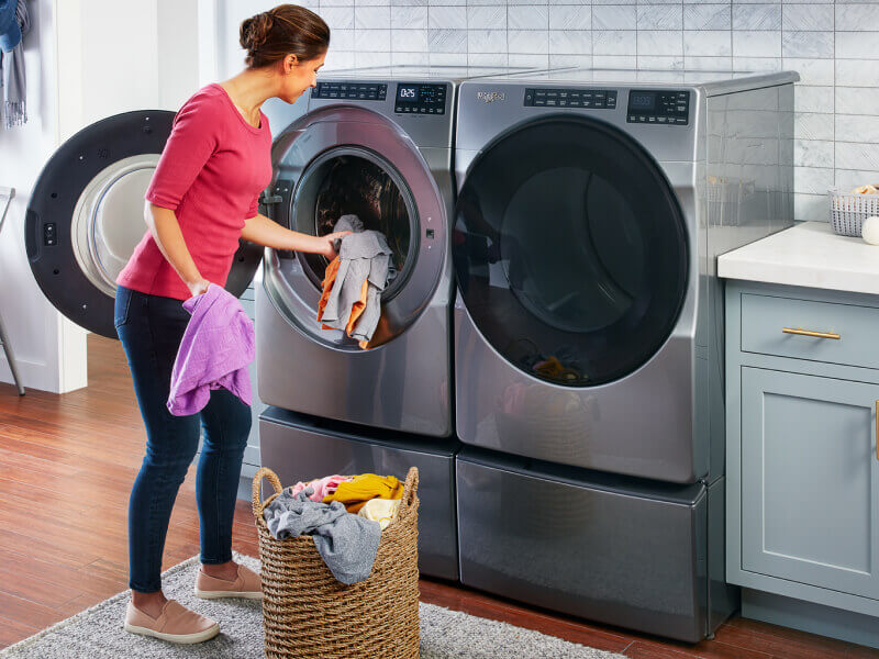 Person putting clothes in the washing machine