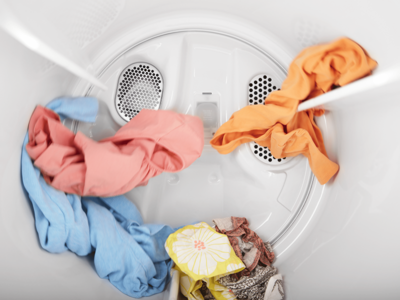 A small load of laundry tumbling in a dryer.
