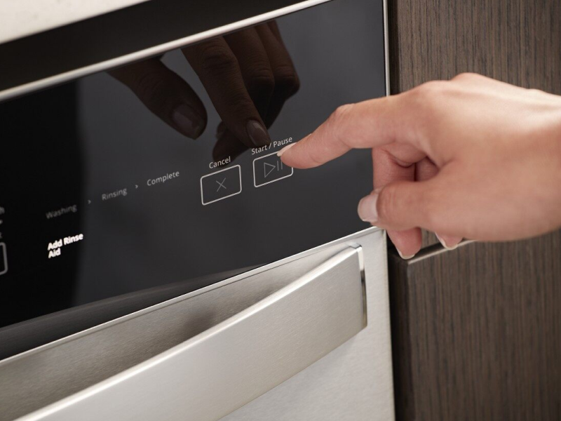 Person selecting a dishwasher wash cycle