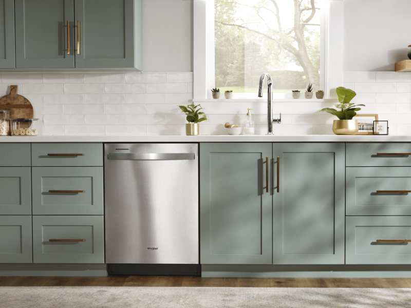 Stainless steel Whirlpool® top control dishwasher in a rustic kitchen