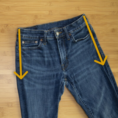 A flat pair of jeans with arrows pointing down