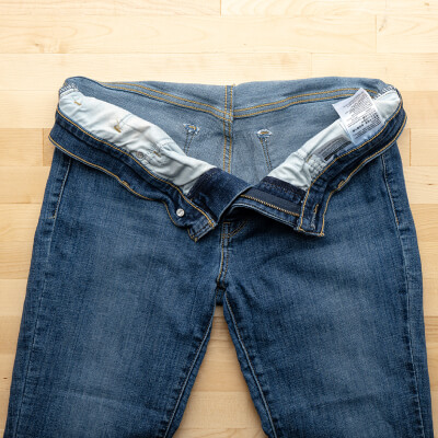 Jeans placed flat on a table with the pockets emptied out