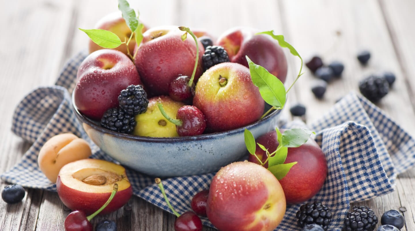 A bowl of peaches, cherries and blackberries