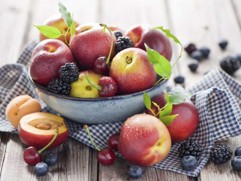 A bowl of peaches, cherries and blackberries