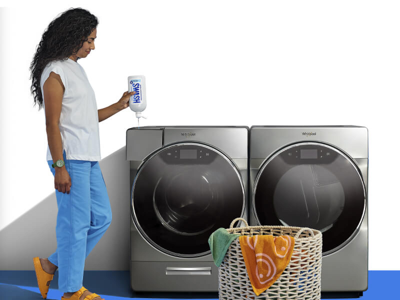 Woman adding Swash® detergent in a front load washing machine