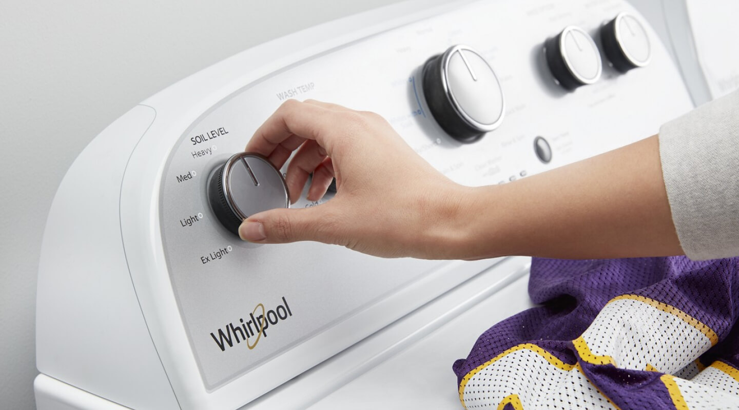 Person selecting a setting on a Whirlpool® Washing Machine