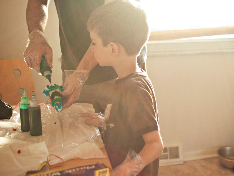 An adult and child crafting with paints