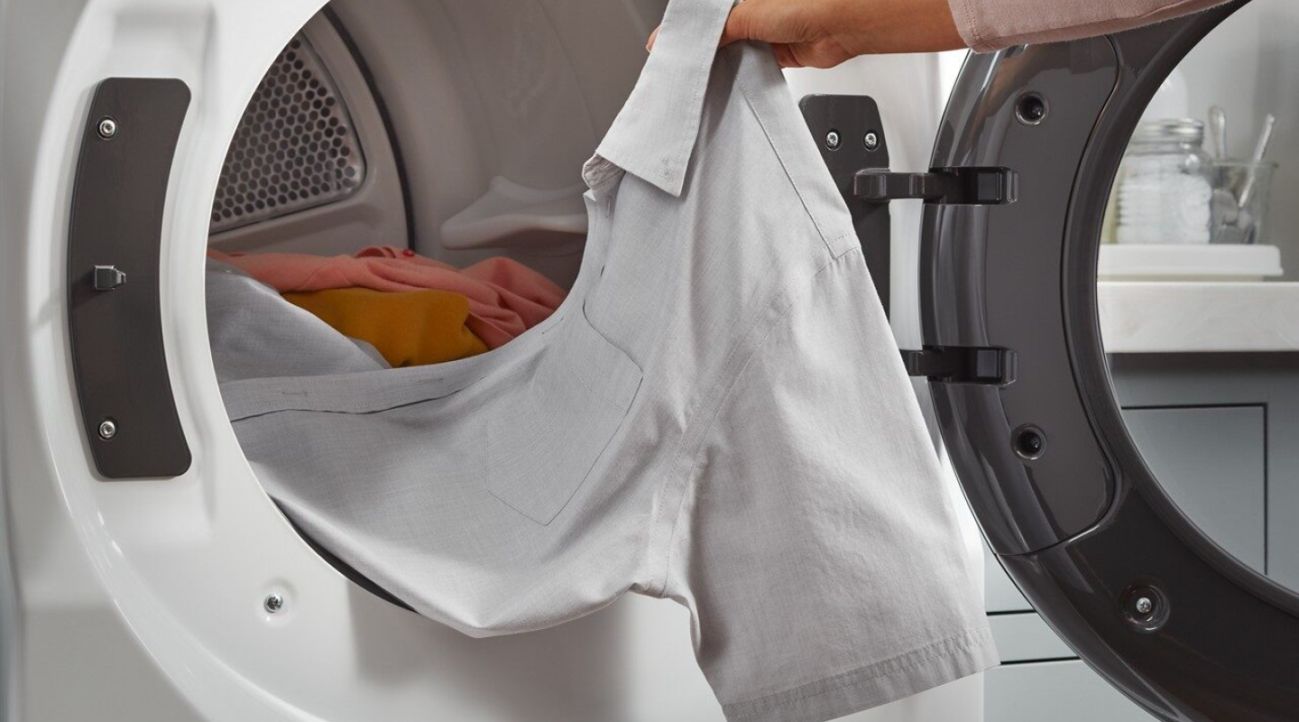 Person removing a shirt from a dryer