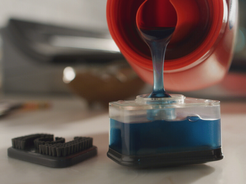 Person filling a stain spot treater with detergent