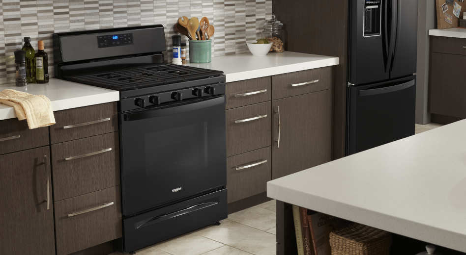 Black Whirlpool® range placed between brown cabinets