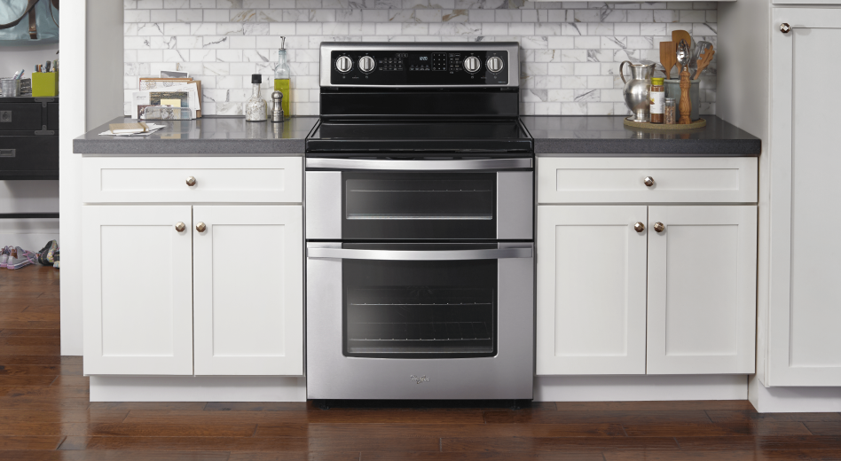 Stainless steel double oven installed between white cabinetry
