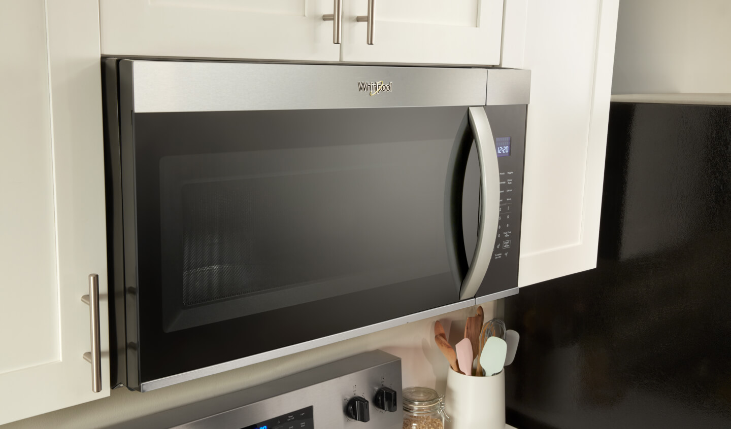 A Whirlpool® Over the Range Microwave that's built into white cabinetry