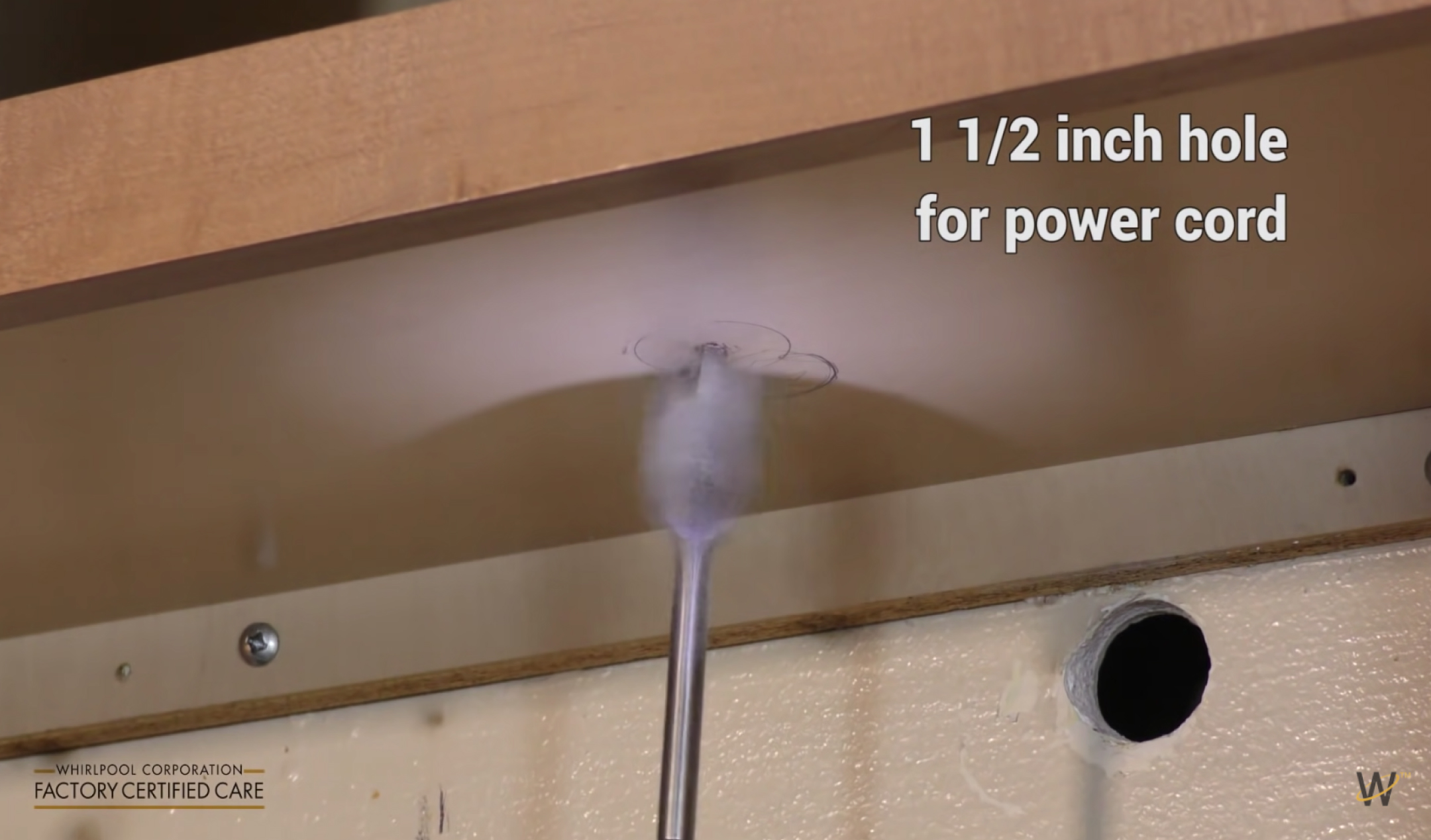 Hole being drilled into the upper cabinet for the microwave power cord