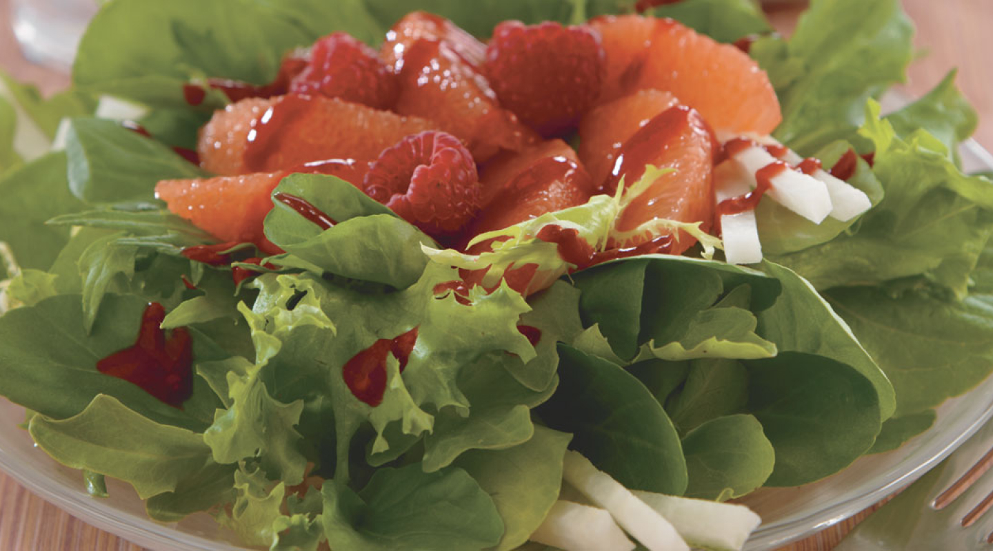 A salad topped with fresh fruit