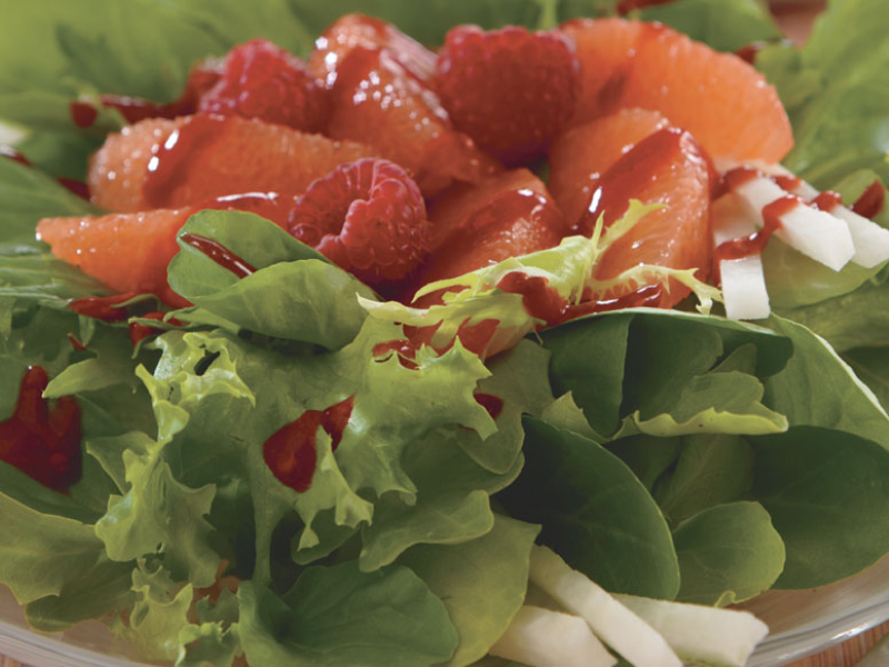 A salad topped with fresh fruit