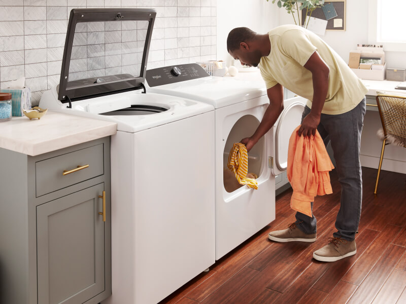 A man takes laundry out of a dryer