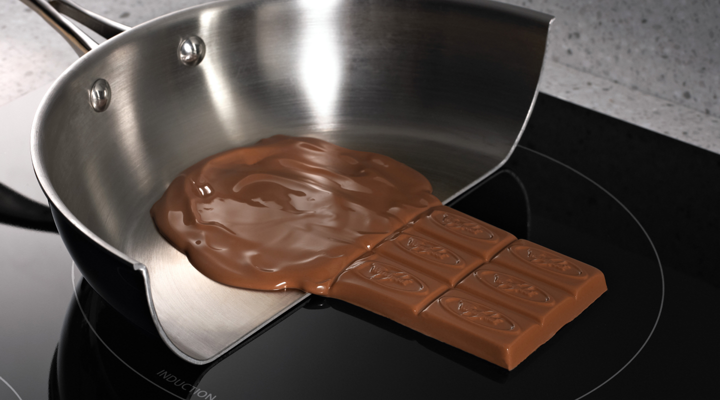 Melted chocolate in a pan on a glass cooktop