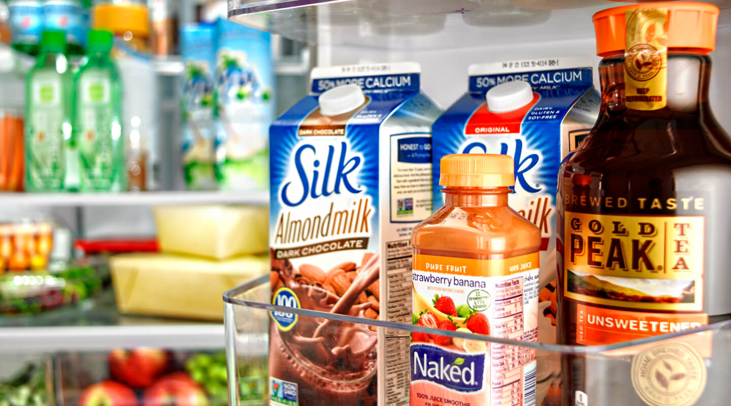 Juice, milk and coffee containers inside a refrigerator