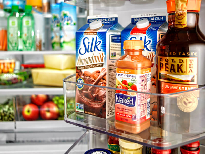 Juice, milk and coffee containers inside a refrigerator
